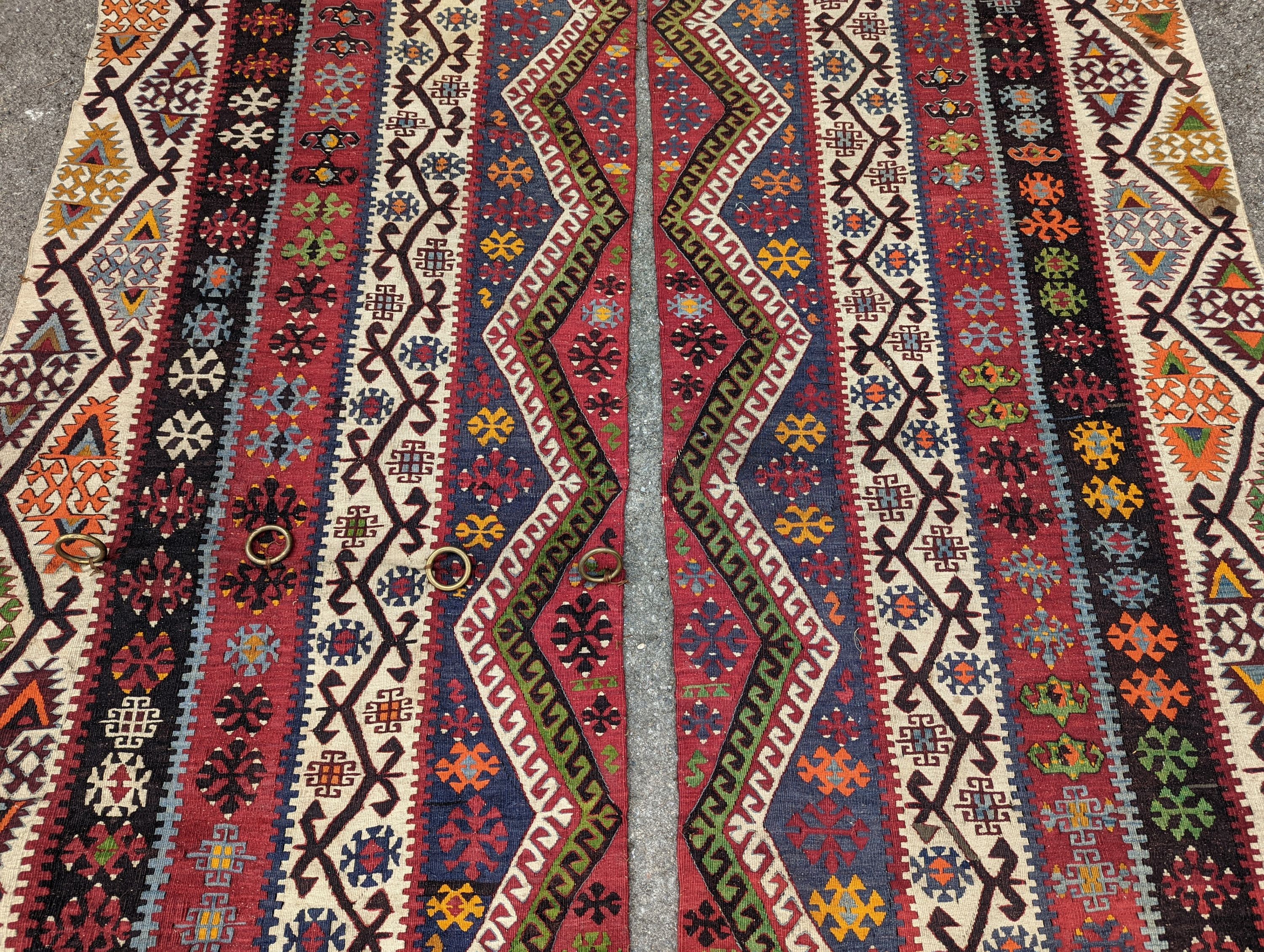 A Kilim polychrome flatweave carpet, cut centrally to create a pair of runners, each 440 x 97cm
